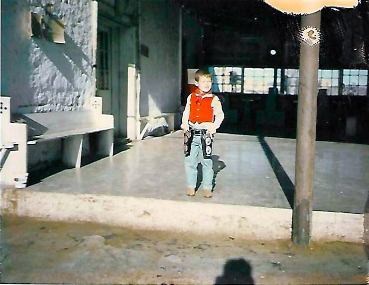Boy on Porch of Lajitas Trading Post dressed as old west cowboy - circa 1962