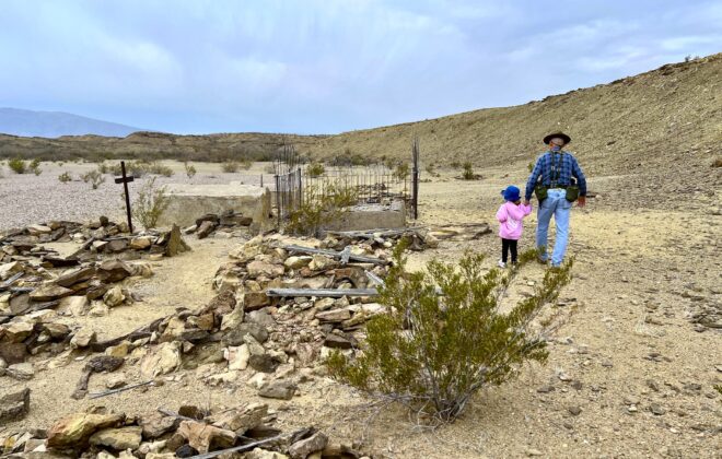 Man and small child visit a remote cemetary.