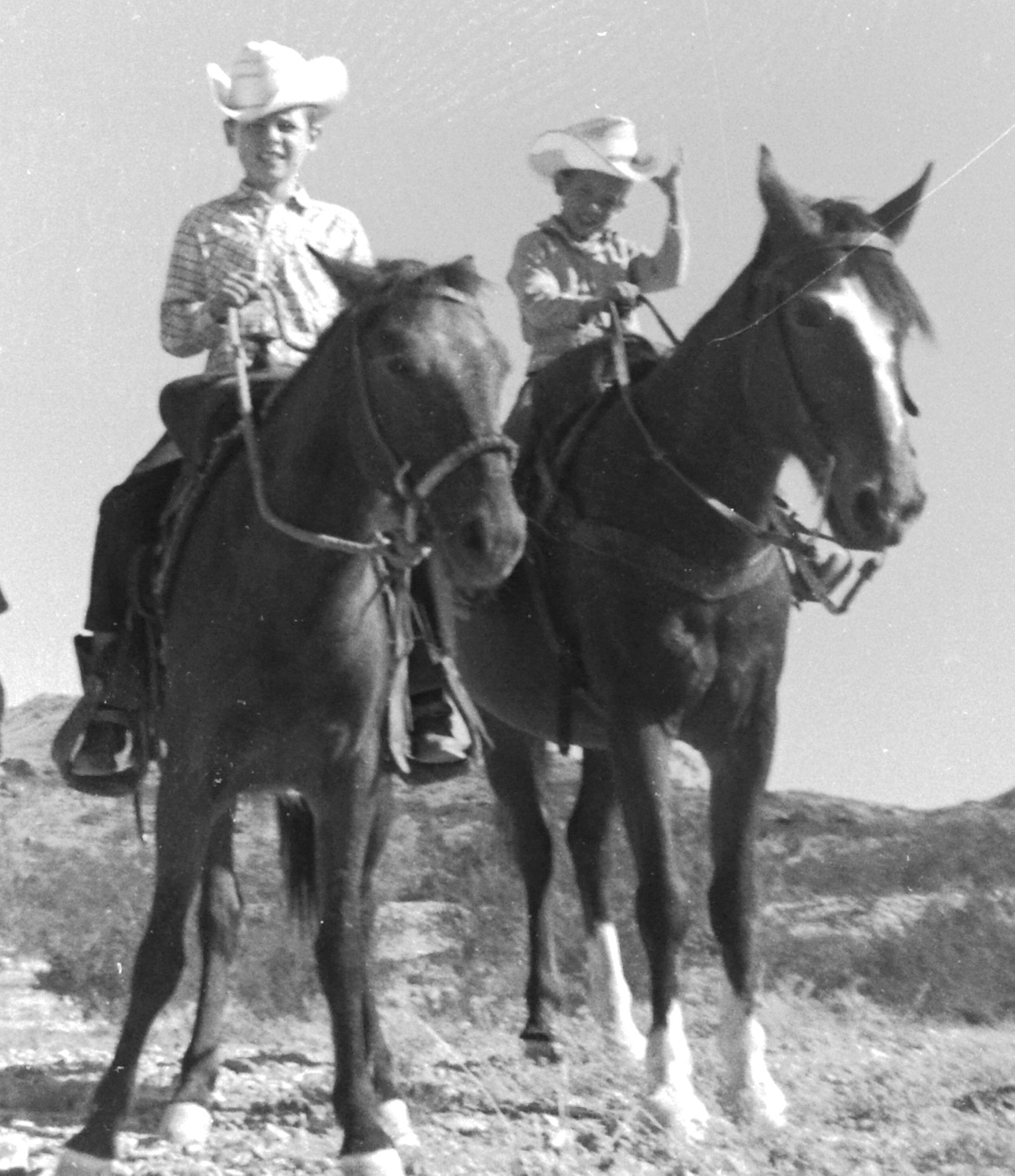 Ben and Brother Barry Black and white photo of two young boys in cowboy hats riding horses.