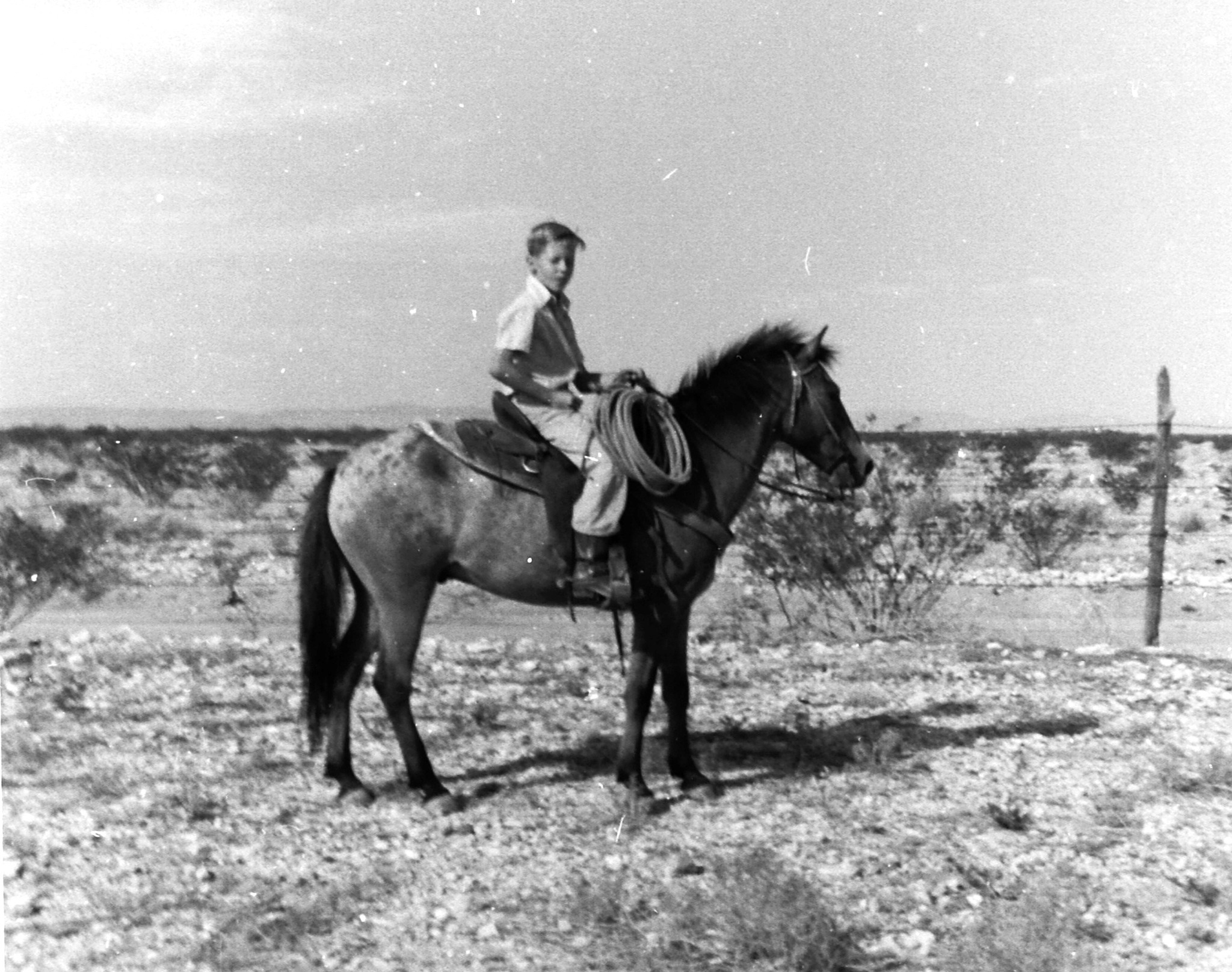 Barry Riding in the Big Bend of Texas Black and white photo of a young boy on horseback with desert scenery behind him.